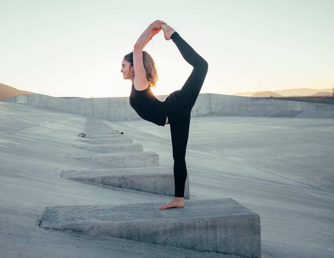 shallow-focus-photo-of-woman-in-black-sleeveless-shirt-doing-yoga-nzynzmr3ls